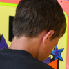 Close-up of boy's head, from back, with colorful background.